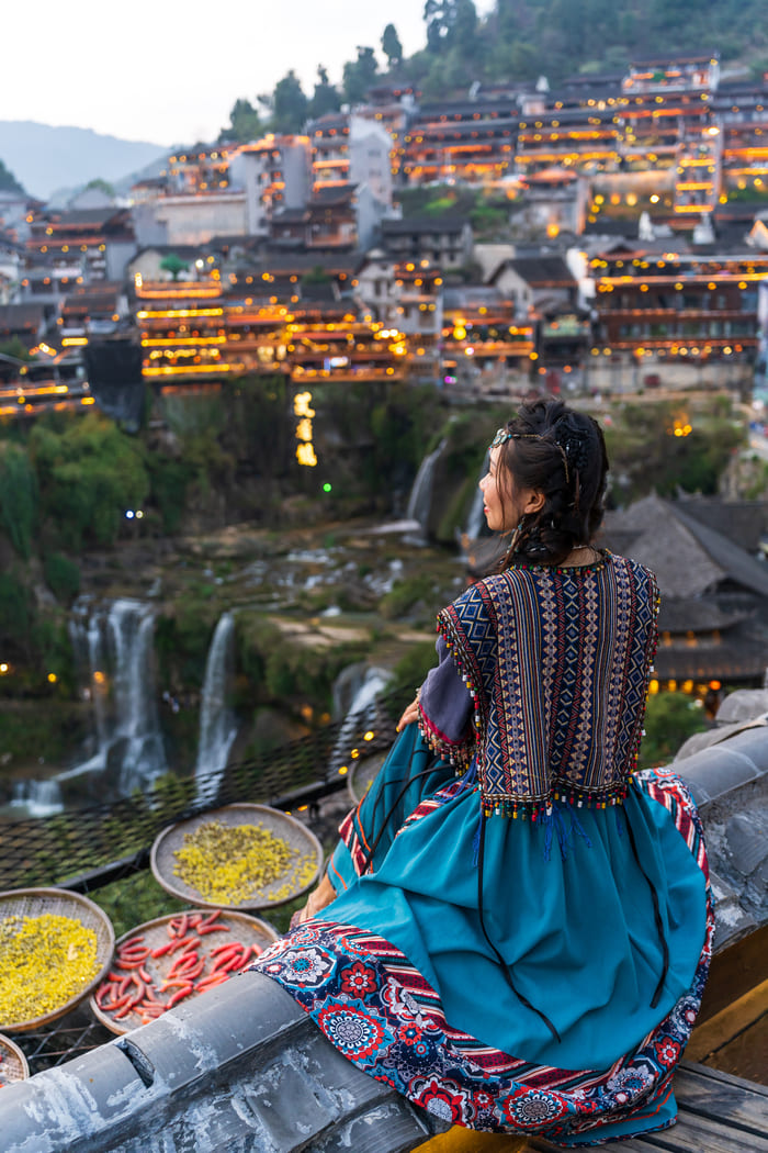 Joven observa la ciudad Lijiang