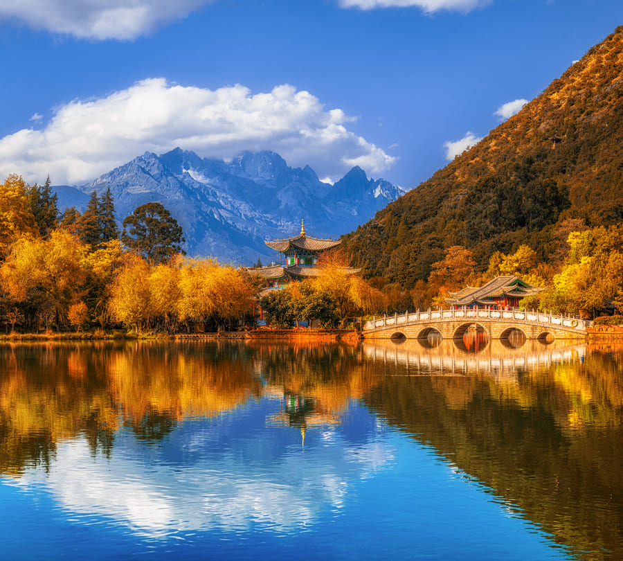 Paisaje de un rio y montañas en Lijiang, con un cielo azul despejado