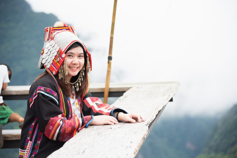 Chica con ropa tradicional, observando las montañas en mhong